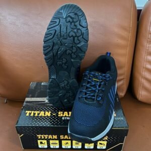 Đế giày bảo hộ lao động Titan Safety ELAN màu đen có rãnh chống trượt, một chiếc giày được lật và một chiếc đặt đứng.