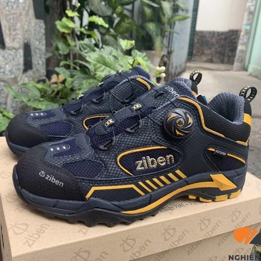 Đôi giày Ziben-163 phối đen vàng có núm vặn khóa dây, chữ ziben vàng bên hông, đặt trên hộp giày