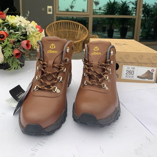 Ảnh thực tế đôi giày Ziben-188 da nâu nhìn thẳng phía trước, dây buộc nâu, khoen kim loại, đặt trên bàn