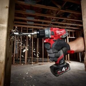 Tay thợ cầm máy khoan Milwaukee M12 FPD-0C lắp pin 4.0Ah, khoan vào dầm gỗ trong khung trần nhà đang thi công