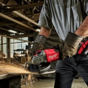 Thợ cơ khí đeo găng da dùng máy mài góc pin Milwaukee M18 FUEL mài kim loại, tia lửa bắn ra trong nhà xưởng
