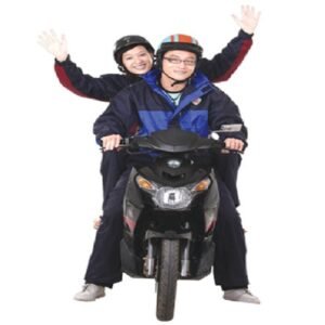 Hai người ngồi trên xe máy mặc quần áo mưa Rando 1 lớp B+ màu xanh than phối xanh dương, đội mũ bảo hiểm, giơ tay vẫy