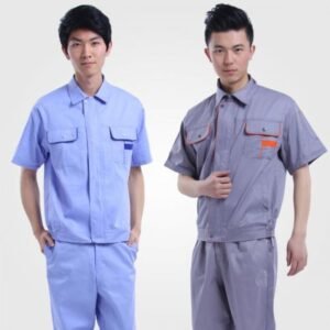 Hai nam mặc quần áo bảo hộ ngắn tay phối màu, một bộ xanh nhạt túi viền xanh đậm, một bộ xám có viền cam ở túi ngực